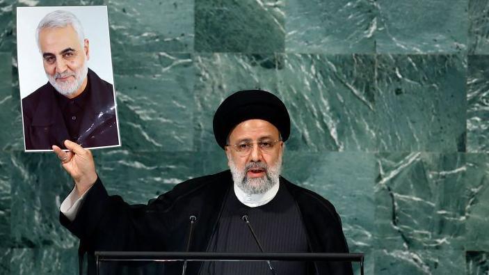 The late Iranian president, Ebrahim Raisi holds a photo of Soleimani at the UN in 2022