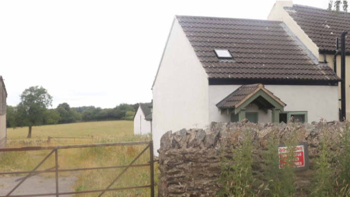 A white cottage with countryside views from the rear