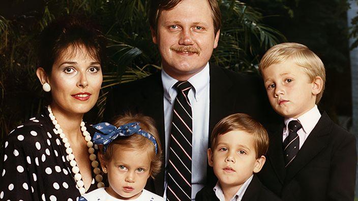 A woman and a man and three small children, all of whom are smartly dressed