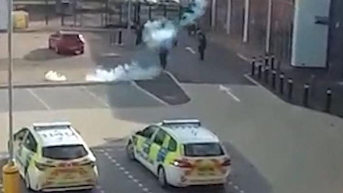 A slighty blurry CCTV image showing Mr Ciolac surrounded by officers in a car park