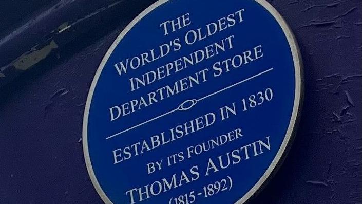 A blue plague that hangs outside the former Austins department store in Derry denoting the year it opened and that it is the 'worlds oldest independent department store'