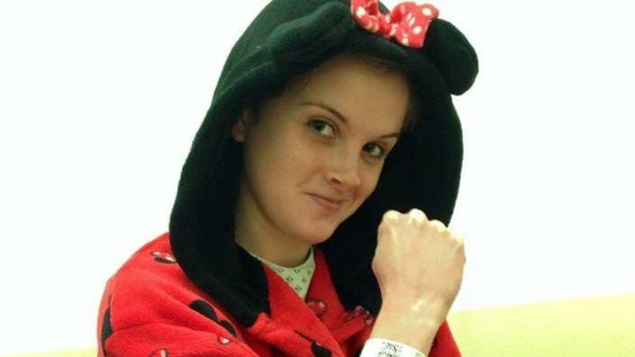 Charlotte dressed in a mini mouse dressing gown in hospital ready to have brain surgery to remove part of her skull.