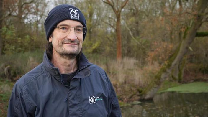 Darren Tansley standing beside a recently-restored pond at Panfield, near Braintree