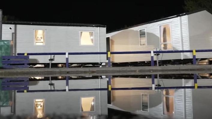 Two caravans at night surrounded by floodwater