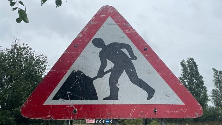 Stock image of a roadworks sign in a red triangle.