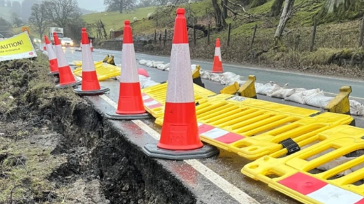 A section of the A59 coned off with a hole at the side of the road.