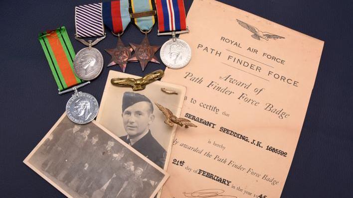 A collection of war medals, a photograph of Flt Sgt Spedding, the RAF's Pathfinder Force and an official letter accompanying the award of the DFM which were sold at auction.