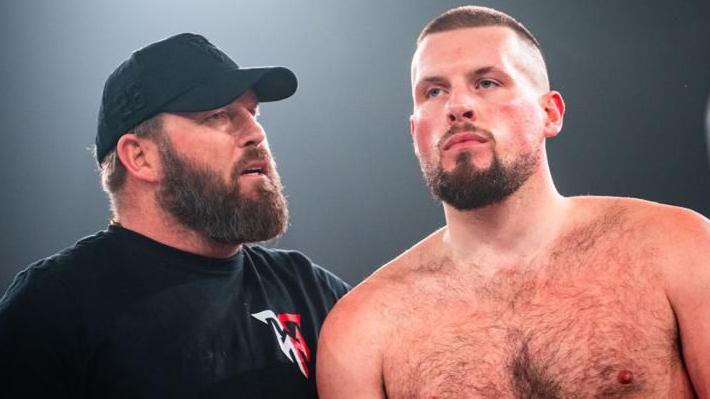 Former boxer Scott Welch, wearing a hat on the left, with his son Tommy, on the right, bare-chested after a boxing match.