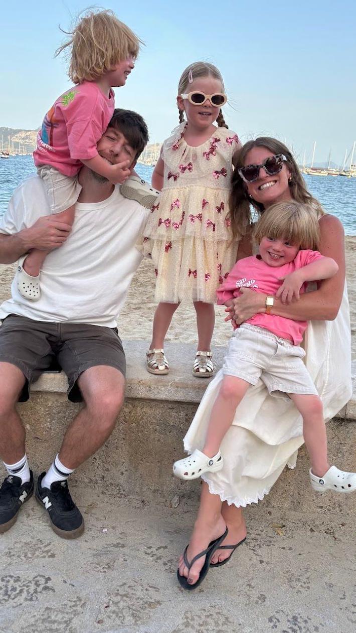 A mum and dad pictured by the seaside with their two young children.