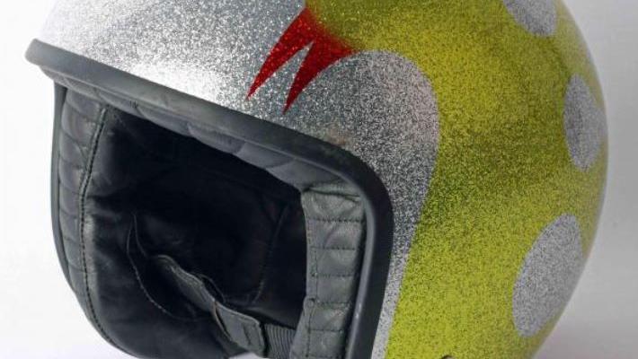 Myers' old-style, rounded, glittery silver biker's helmet, featuring a bird in yellowy gold glitter, with a red glitter beak.