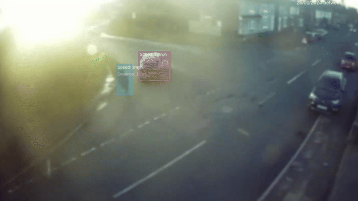 A man crossing the road is highlighted in blue with a vehicle close by him in the road highlighted in pink by the cameras that captured the data.