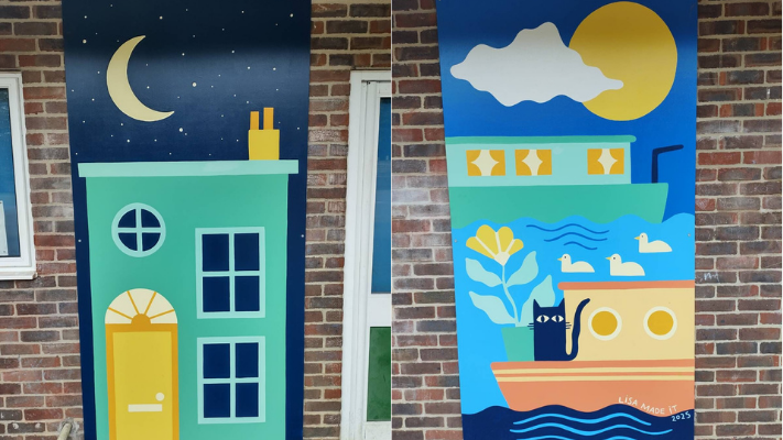 Murals on the side of the school building depicting a cat on a boat and ducks in the water, and a Jericho house at night.
