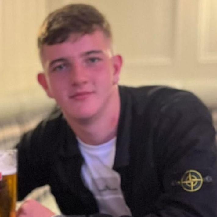 Cole wearing a black jacket and white t-shirt