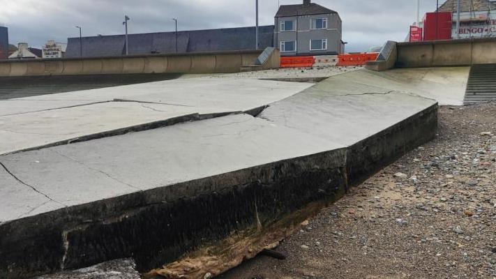 Damage to the Dundas Street slipway in Redcar. There are concrete slabs which have broken and are facing up at awkward angles on the side leading into the sea.