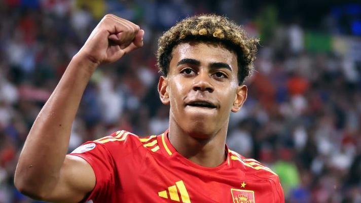 Spain's Lamine Yamal raises a clenched right fist while wearing Spain's national team kit