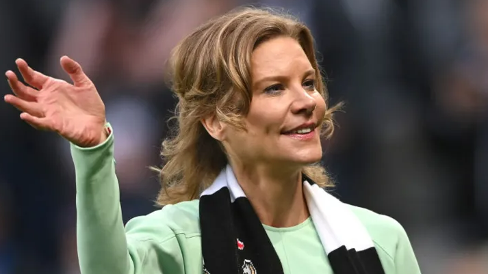 Amanda Staveley waving while wearing a Newcastle scarf