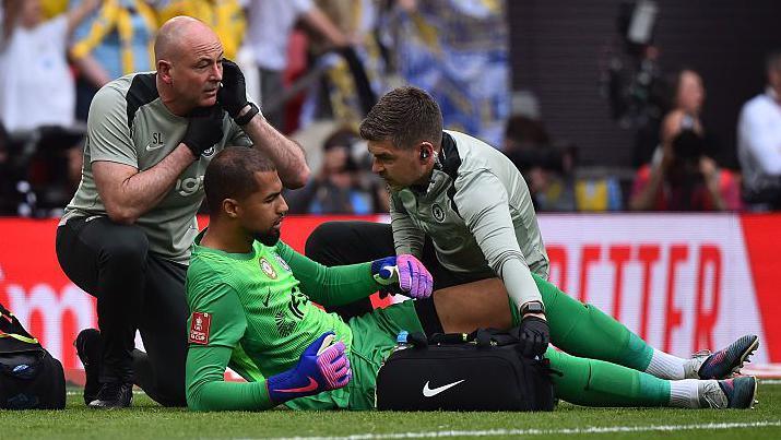 Robert Sanchez receives treatment for an apparent injury during the FA Cup semi-final between Chelsea and Leeds United at Wembley Stadium