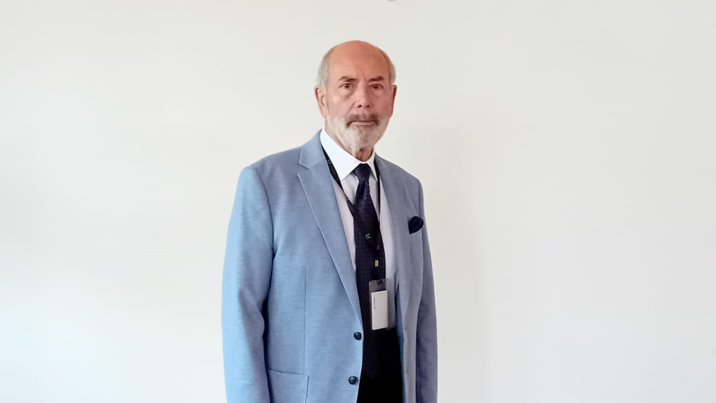 A man in a jacket and tie against a white background