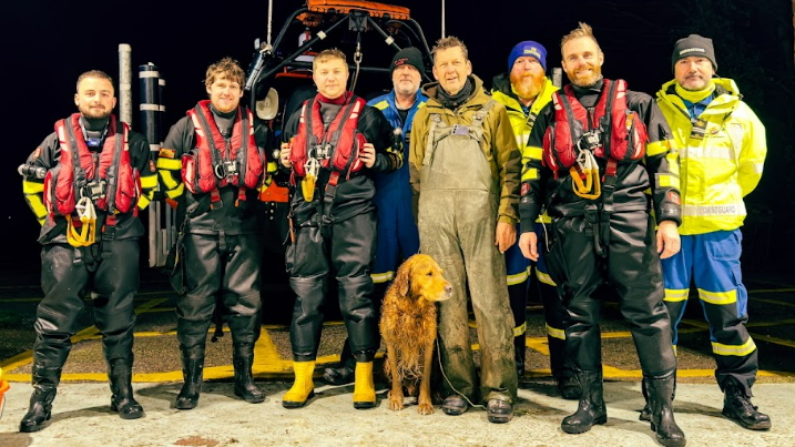 Buddy the dog stands for a group photo with the team at Humber rescue, after he arrived at the station.  The four crew members are still in their life jackets and wellies.