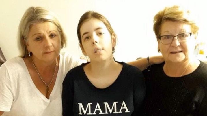 Chloe with her aunt Lisa and grandmother Jeannette. She is wearing a top that says 'Mama' on it. 