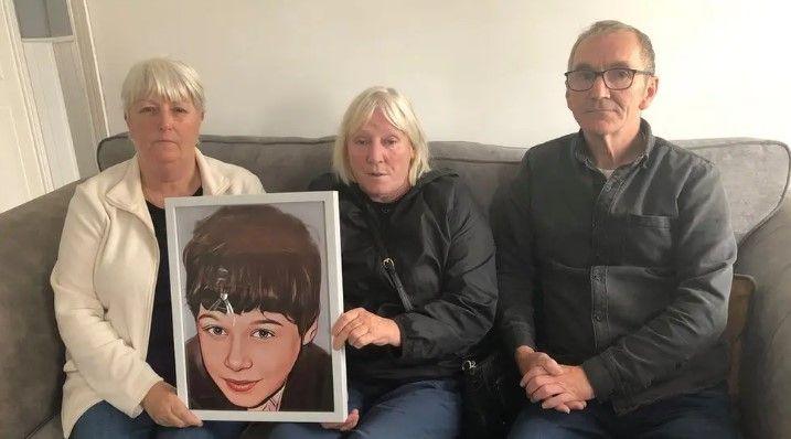 Picture of Daniel Hegarty's relatives pictured on a sofa holding a portrait photo of the 15-year-old