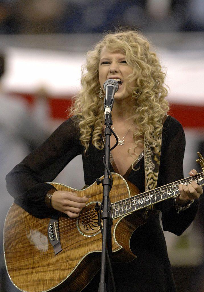 16 year old Taylor playing a wood effect guitar
