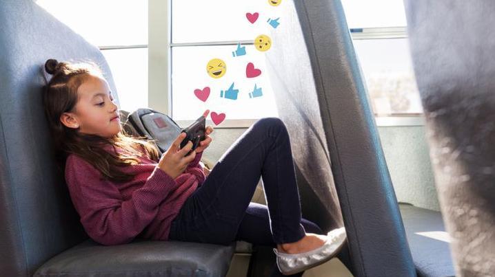 girl on phone, on the bus, emoji gfx coming out of phone