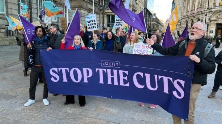 Men and women with banners and flags during a protest against council cuts