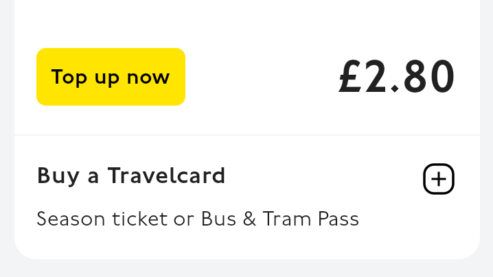 A close up of the app where the option of topping up credit or buying a bus or tram season ticket are displayed. The top up button is yellow with black text. 