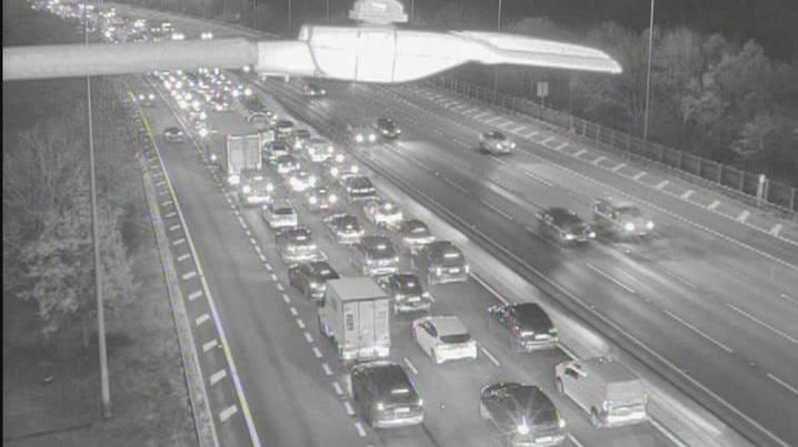A black and white image shows lots of vehicles in three or four lanes on a motorway