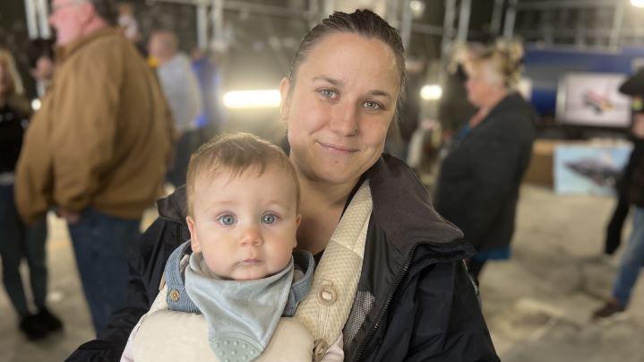 Thirty-year old Cat Jones with her hair tied back and a black coat on with her baby Frankie with blue eyes peering intently into the camera