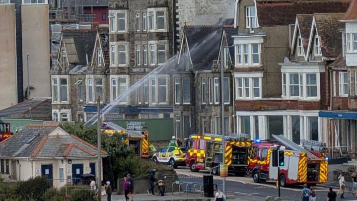 Fire engines at the scene of an incident on Narrowcliff in Newquay. A stream of water is pointed at the building.