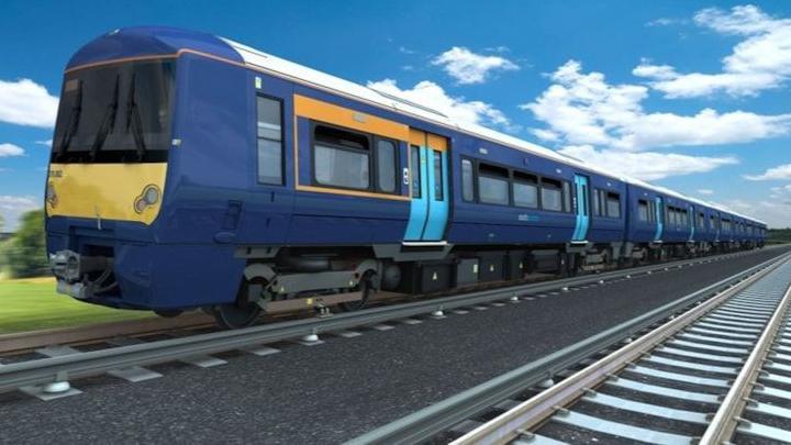 A blue Southeastern train with a yellow front and an small orange stripe on the side of the front of the train.