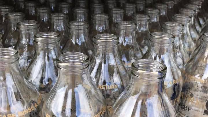 The tops of rows and rows of empty clear milk bottles.
