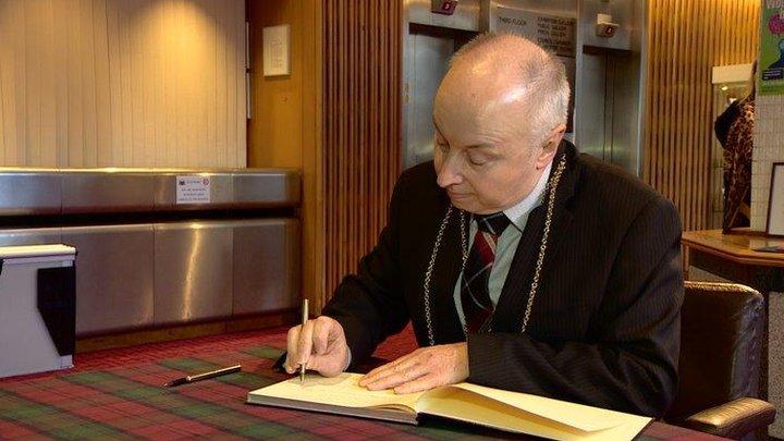 Aberdeen's Lord Provost George Adam signs a book of condolence