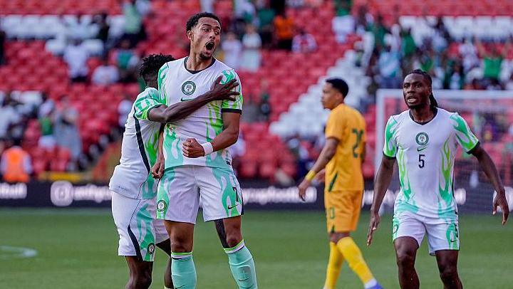 Femi Azeez in a green and white Nigeria kit jumps to celebrate a goal against Zimbabwe
