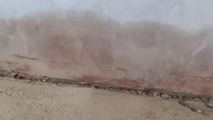 Dry plaster with a line of dampness rising from the floorboards.