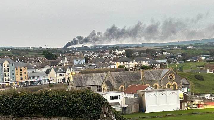 A plume of smoke  billows over a Cornish town