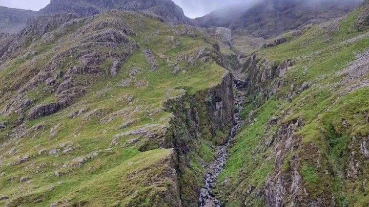 A rocky gully with clouds at the top.