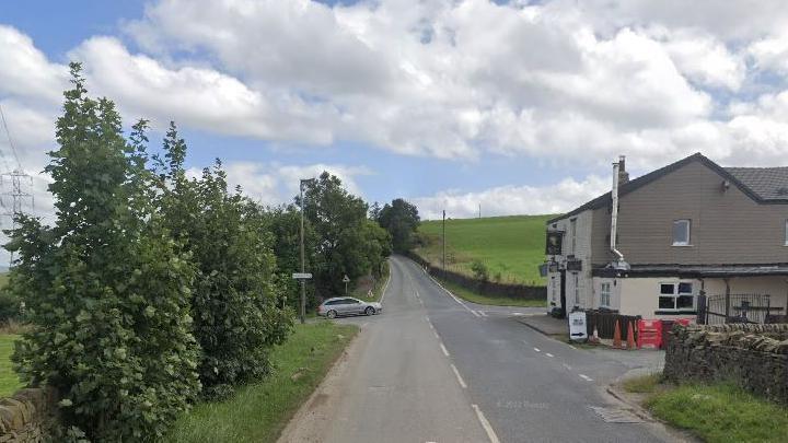 Broken Stone Road junction surrounded by countryside and a pub and other buildings