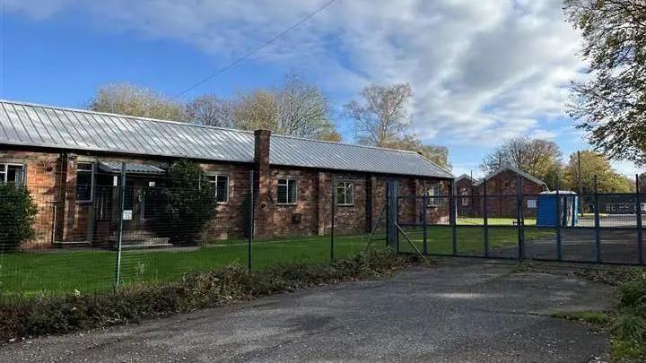 An exterior view of Crowborough Training Camp form outside the perimeter fence and locked gates.