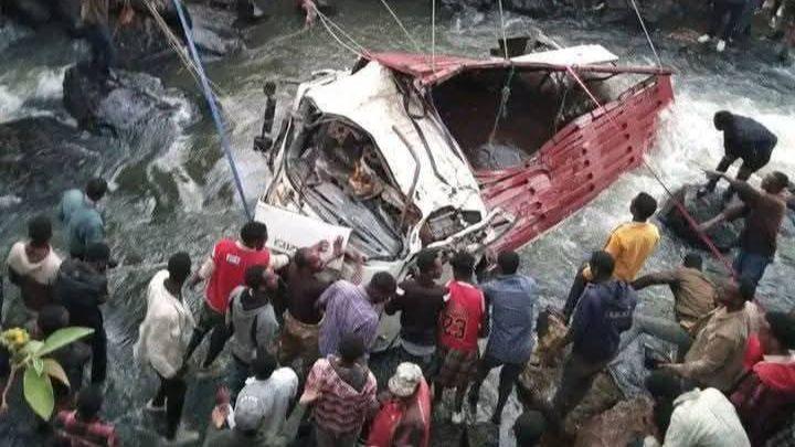 A group attempt to pull a damaged vehicle from a body of water