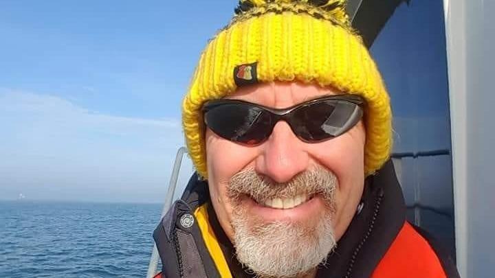 Man wearing bright yellow hat at sea 