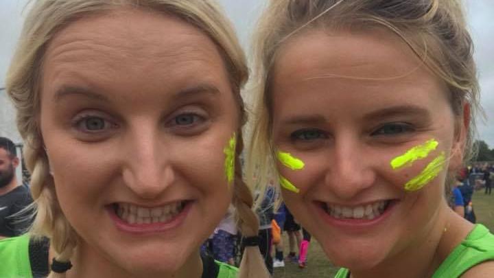 Close-up of both sisters smiling into the camera at a running event