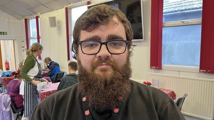 Charlie Buckingham with a big black beard stands in The Salvation Army Hall in Sheerness