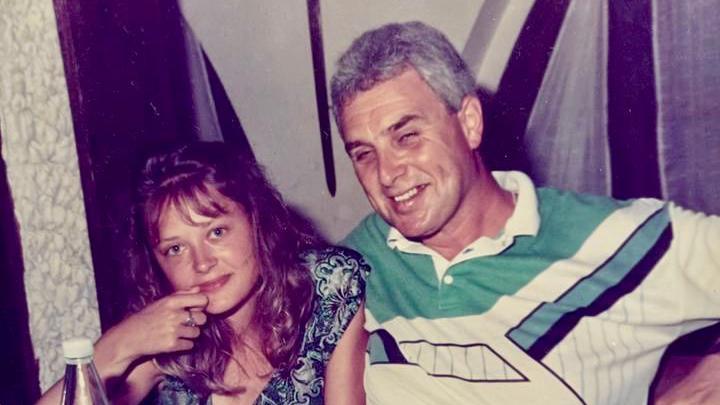 Young Paula and her dad, Keith Richards smiling at the camera in their home.