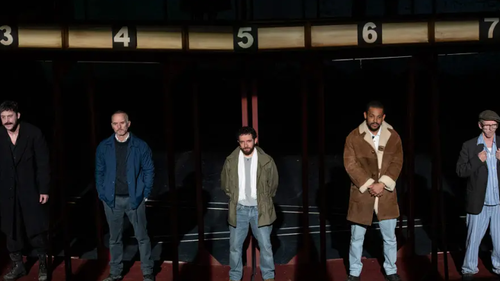Five actors stand side by side on stage during a production of Boys from the Black Stuff.