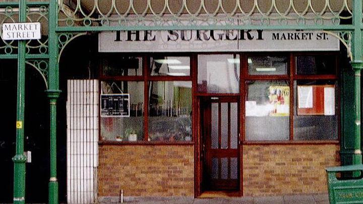 Exterior of doctors surgery called The Surgery on Market Street, Hyde, showing the front door open