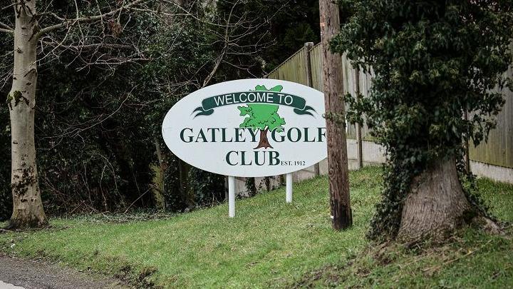 Sign for Gatley Golf Club at its entrance, surrounded by trees