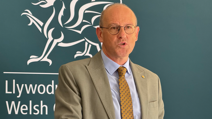 Llyr Gruffydd mewn cynhadledd newyddion ar faes y Sioe Frenhinol